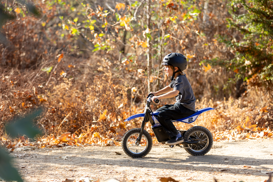 Kid riding the Razor MX125 on a path side
